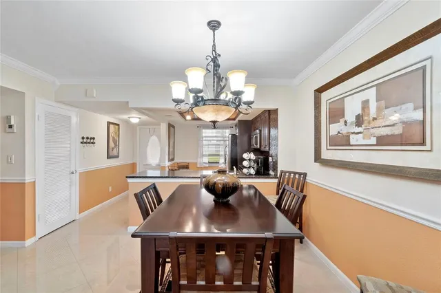 a view of a dining room with furniture a chandelier and wooden floor
