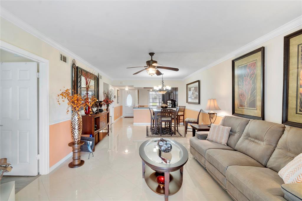 9856 Marina Boulevard, Unit 1311 Boca Raton, FL 33428 - Photo 7 of 26 a living room with furniture a clock and a window