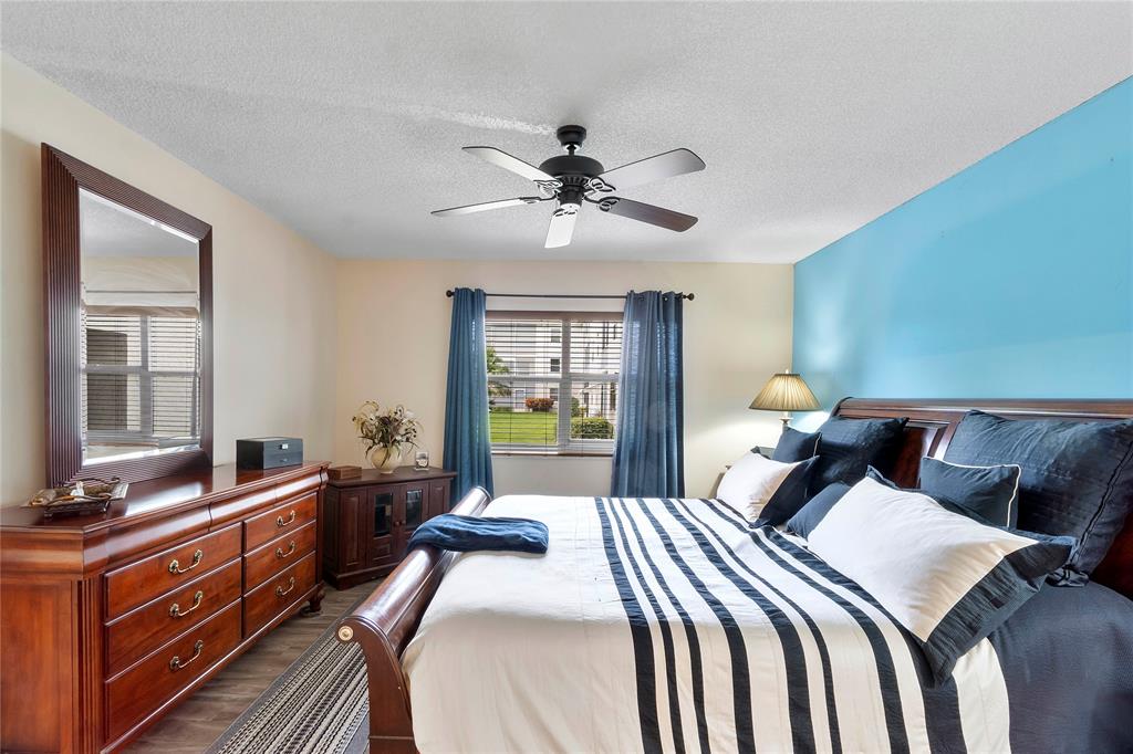 9856 Marina Boulevard, Unit 1311 Boca Raton, FL 33428 - Photo 9 of 26 a bedroom with a bed and a chandelier