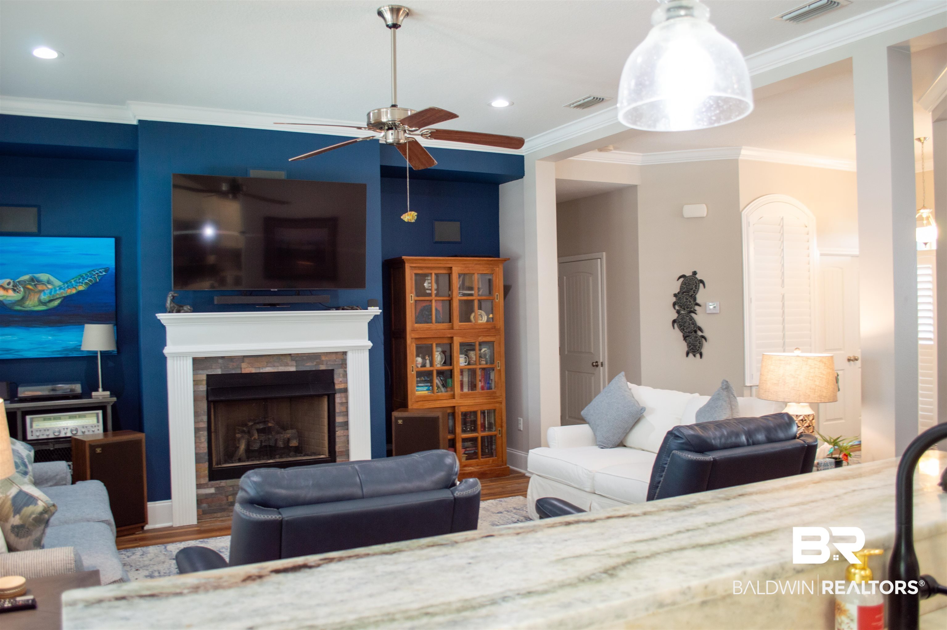 1124 West Orlando Drive Foley, AL 36535 - Photo 9 of 51 Living area featuring crown molding, a ceiling fan, a fireplace, and wood finished floors