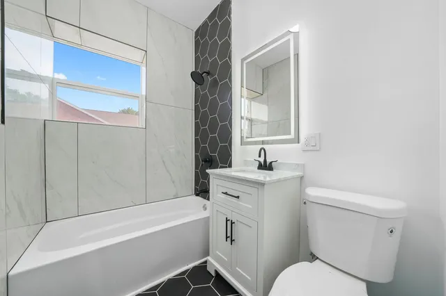 a bathroom with a sink toilet vanity and bathtub