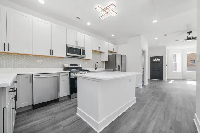 a kitchen with white cabinets and stainless steel appliances