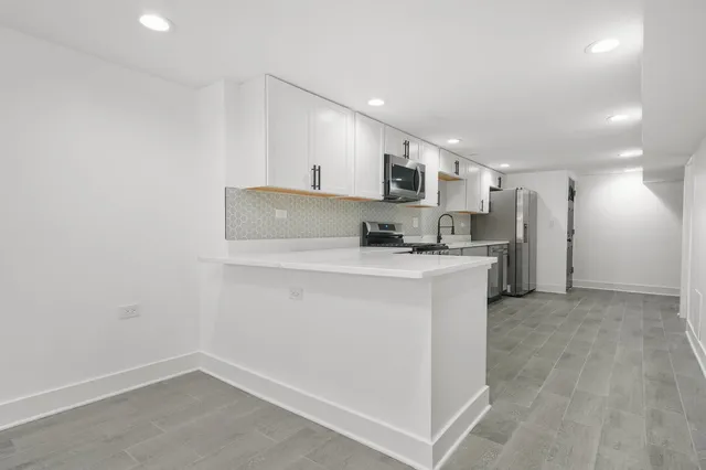 a kitchen with kitchen island a sink appliances and cabinets