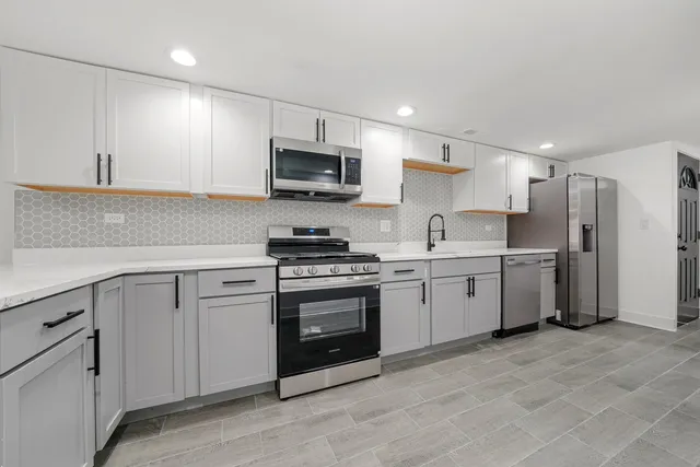 a kitchen with white cabinets stainless steel appliances and sink