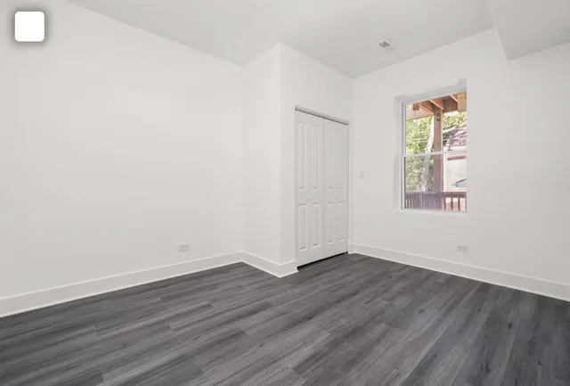 an empty room with wooden floor and window