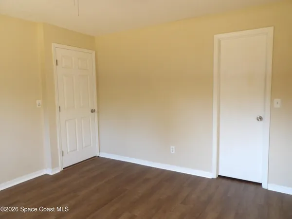 a view of an empty room with wooden floor
