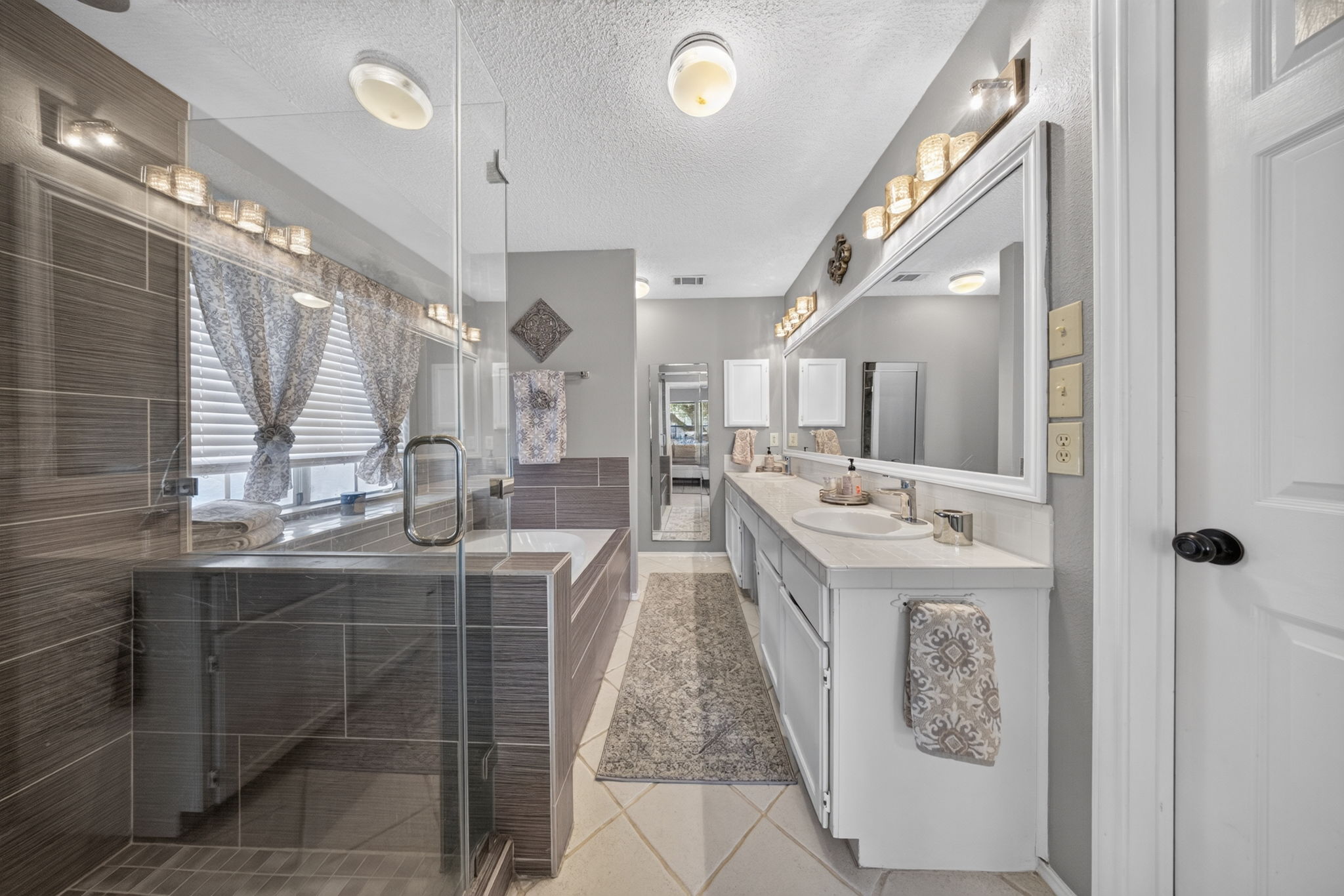 806 Mountain Ridge Drive Leander, TX 78641 - Photo 8 of 40 Tiled accents and a glass shower surround define this well-appointed washroom space.