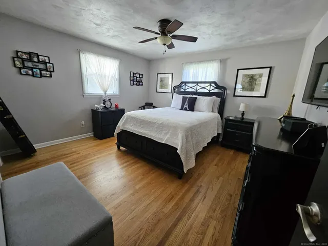 a spacious bedroom with a bed and wooden floor