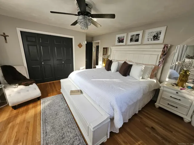 a bedroom with bed and wooden floor