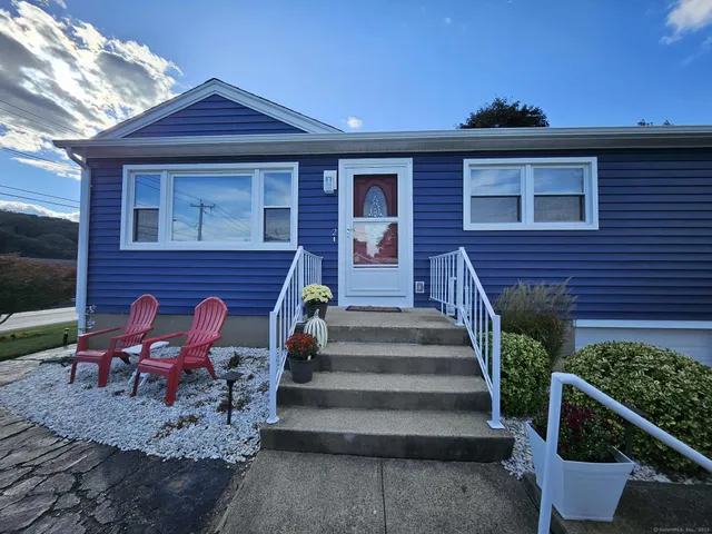 a view of a brick house with chairs and wooden fence