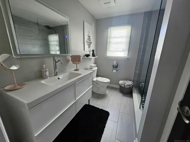 a bathroom with a sink toilet and mirror