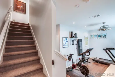 a kitchen with kitchen island a dining table chairs wooden floor and appliances