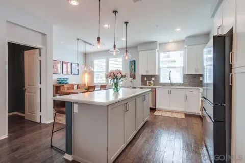 a large kitchen with white cabinets and stainless steel appliances