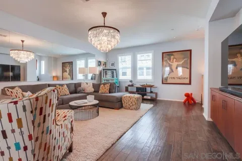 a living room with furniture a flat screen tv and kitchen view