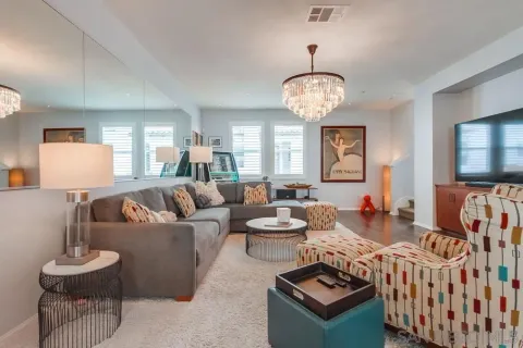 a living room with furniture kitchen view and a chandelier