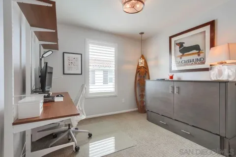 a view of a workspace with furniture and a window