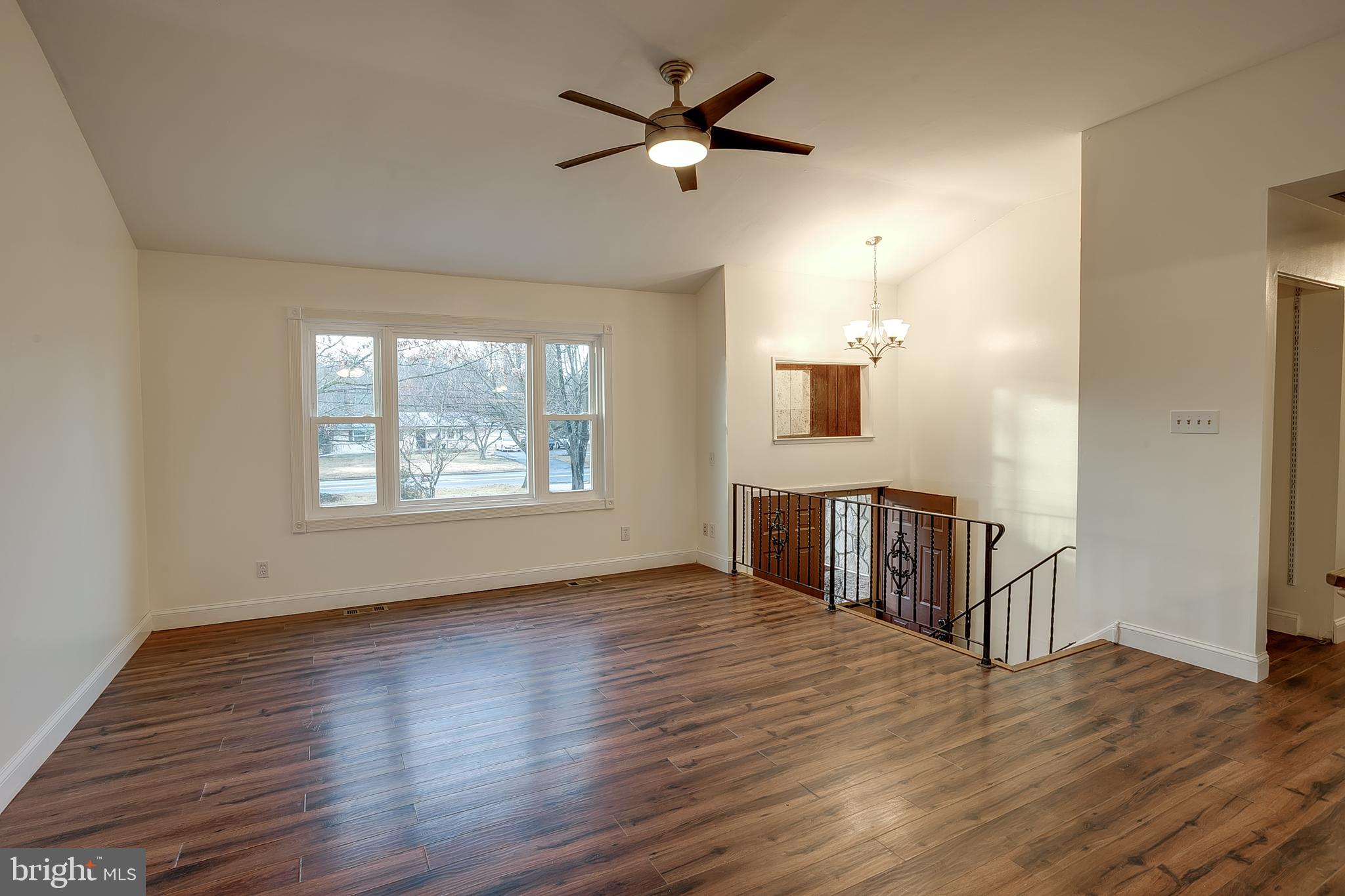 2430 Hopewell Road Berlin, NJ 08009 - Photo 5 of 30 an empty room with wooden floor chandelier fan and windows