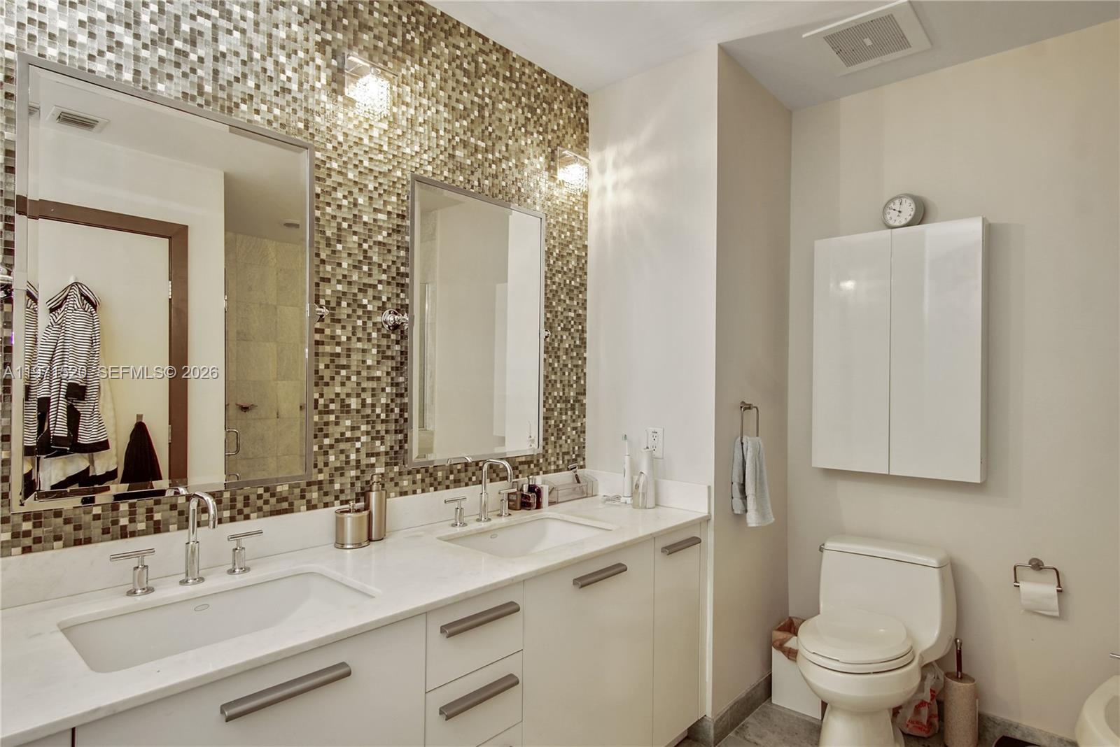 1050 Brickell Avenue, Unit 3406 Miami, FL 33131 - Photo 16 of 20 a bathroom with a double vanity sink mirror and toilet