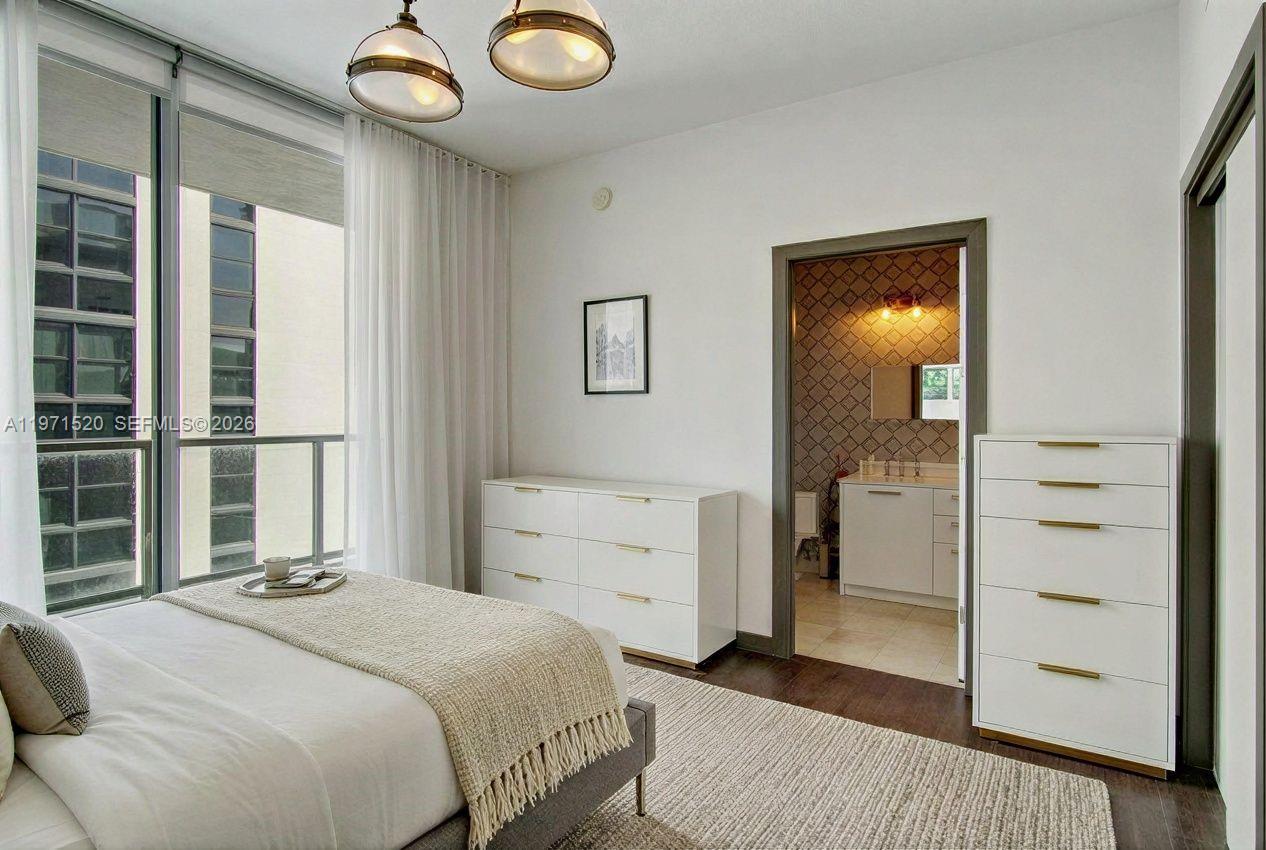 1050 Brickell Avenue, Unit 3406 Miami, FL 33131 - Photo 10 of 20 a bedroom with a bed and a mirror