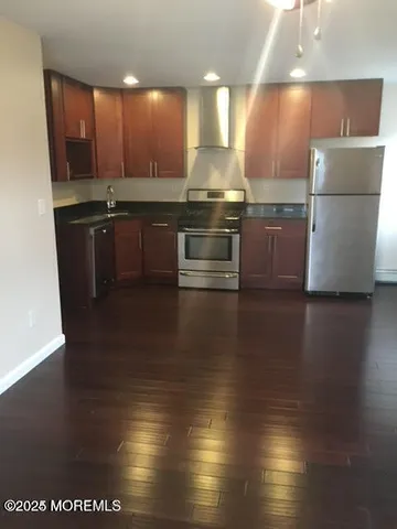 a kitchen with stainless steel appliances a refrigerator a sink a stove a microwave and cabinets