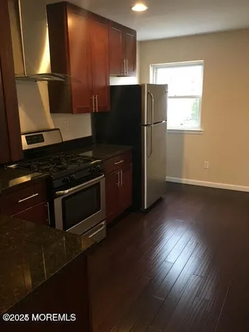 a kitchen with granite countertop wooden floors and stainless steel appliances