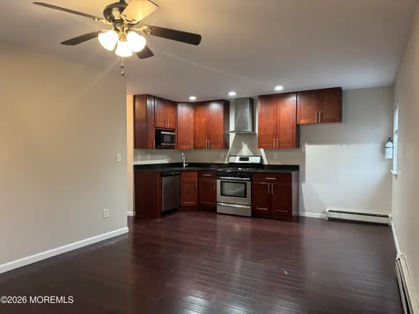 a kitchen with stainless steel appliances granite countertop wooden cabinets and a stove top oven