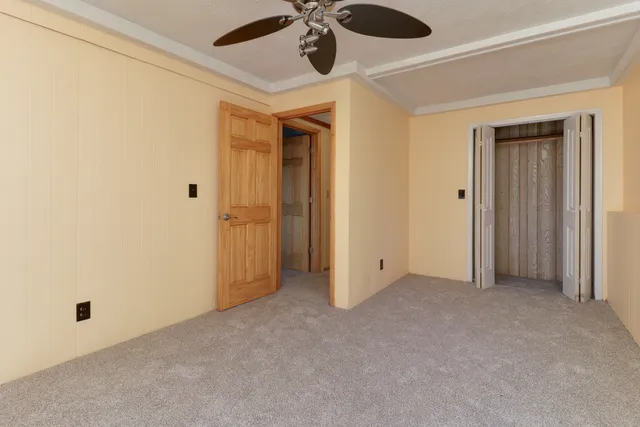 an empty room with a ceiling fan and closet