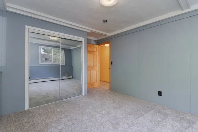 a view of an empty room with a fireplace and a window