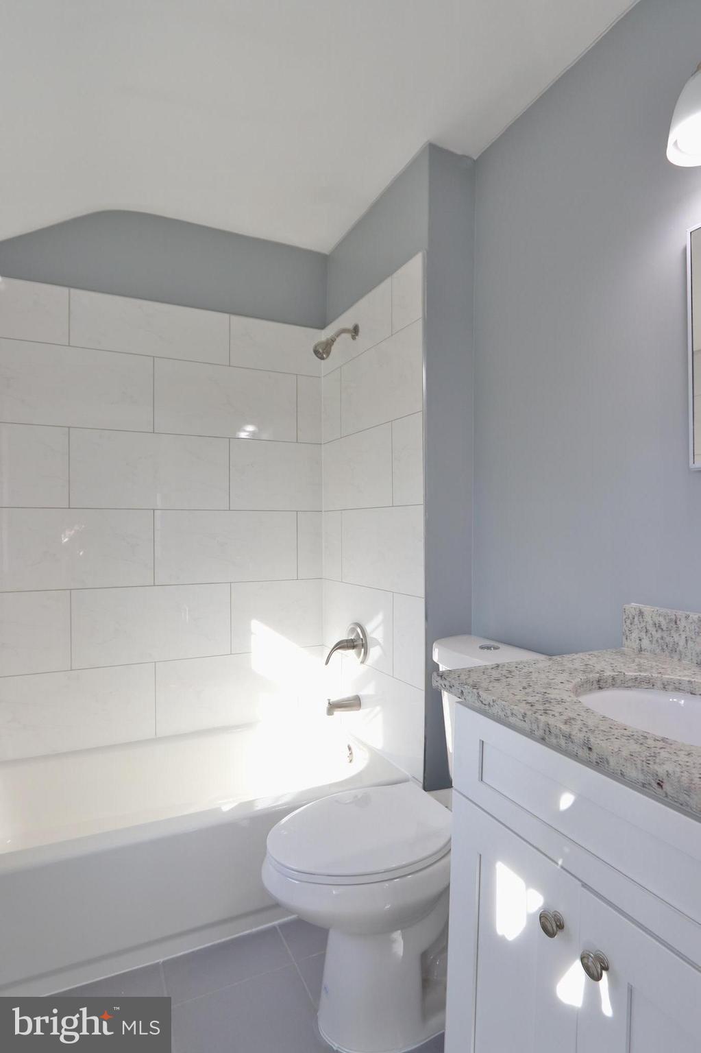 6016 Backlick Road Springfield, VA 22150 - Photo 16 of 24 a bathroom with a granite countertop toilet a sink and bathtub