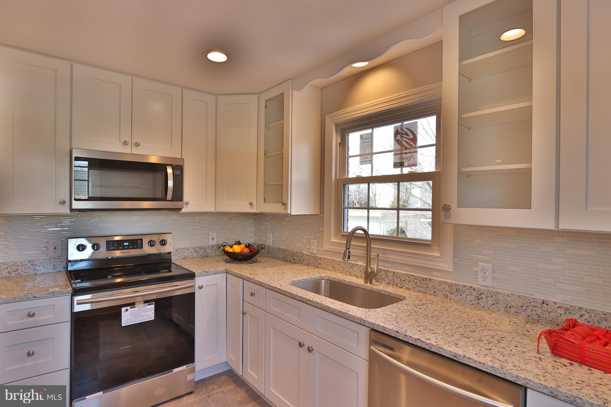 6016 Backlick Road Springfield, VA 22150 - Photo 4 of 24 a kitchen with stainless steel appliances granite countertop a sink a stove and a microwave