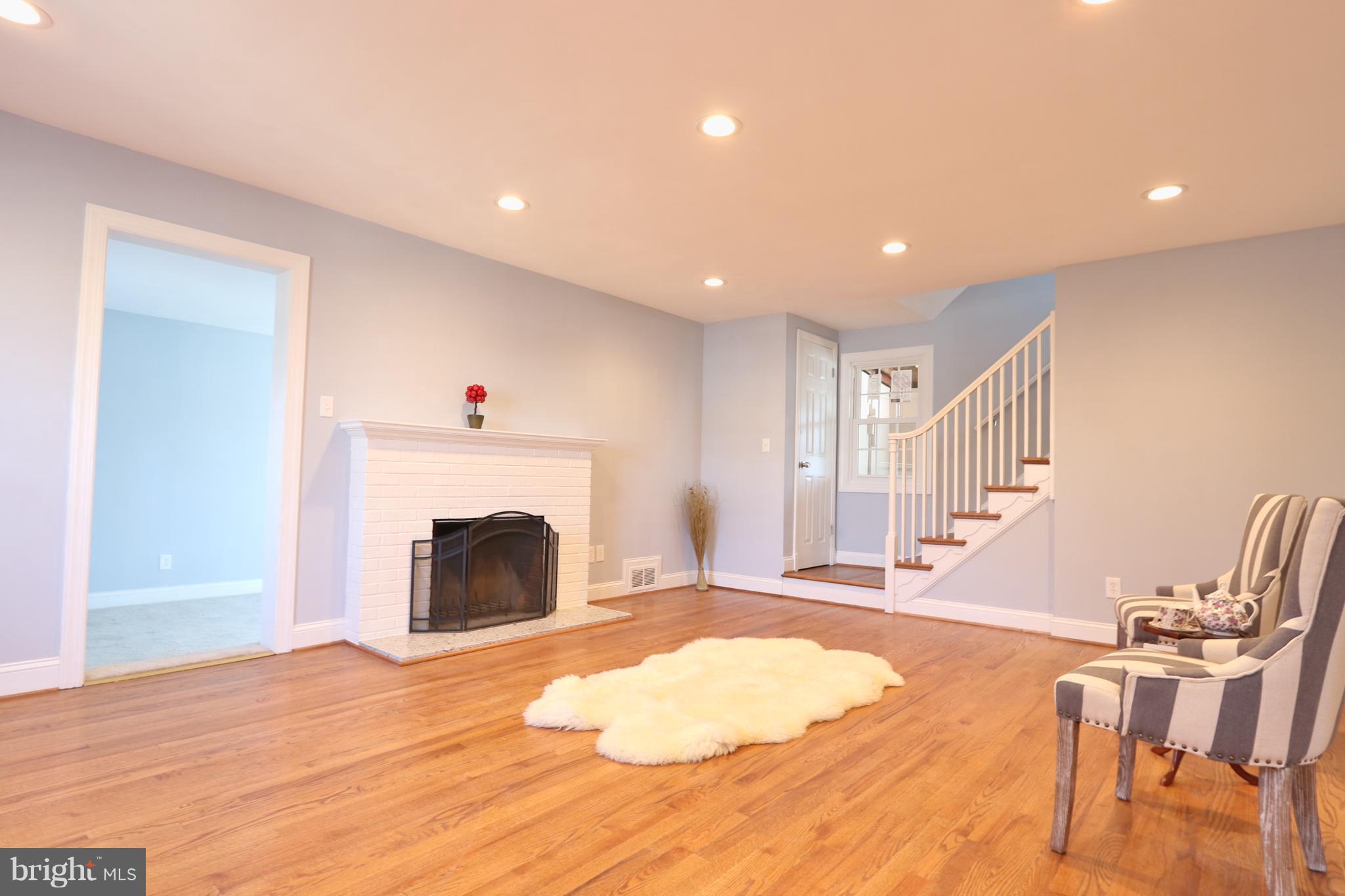 6016 Backlick Road Springfield, VA 22150 - Photo 8 of 24 a view of a livingroom with wooden floor and a fireplace