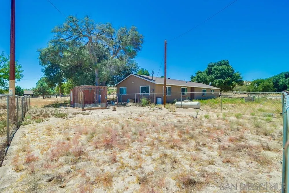 2920 Ribbonwood Road Boulevard, CA 91905 - Photo 58 of 65 a backyard of a house with table and chairs a barbeque with wooden fence