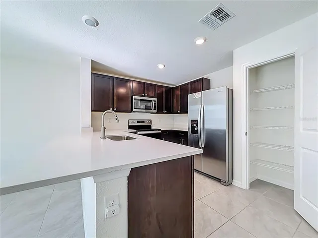 a kitchen with a refrigerator and a sink