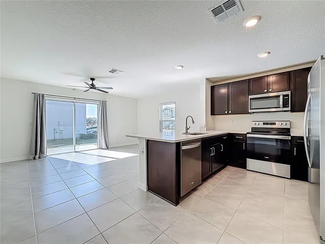 a kitchen with stainless steel appliances granite countertop a refrigerator and a sink