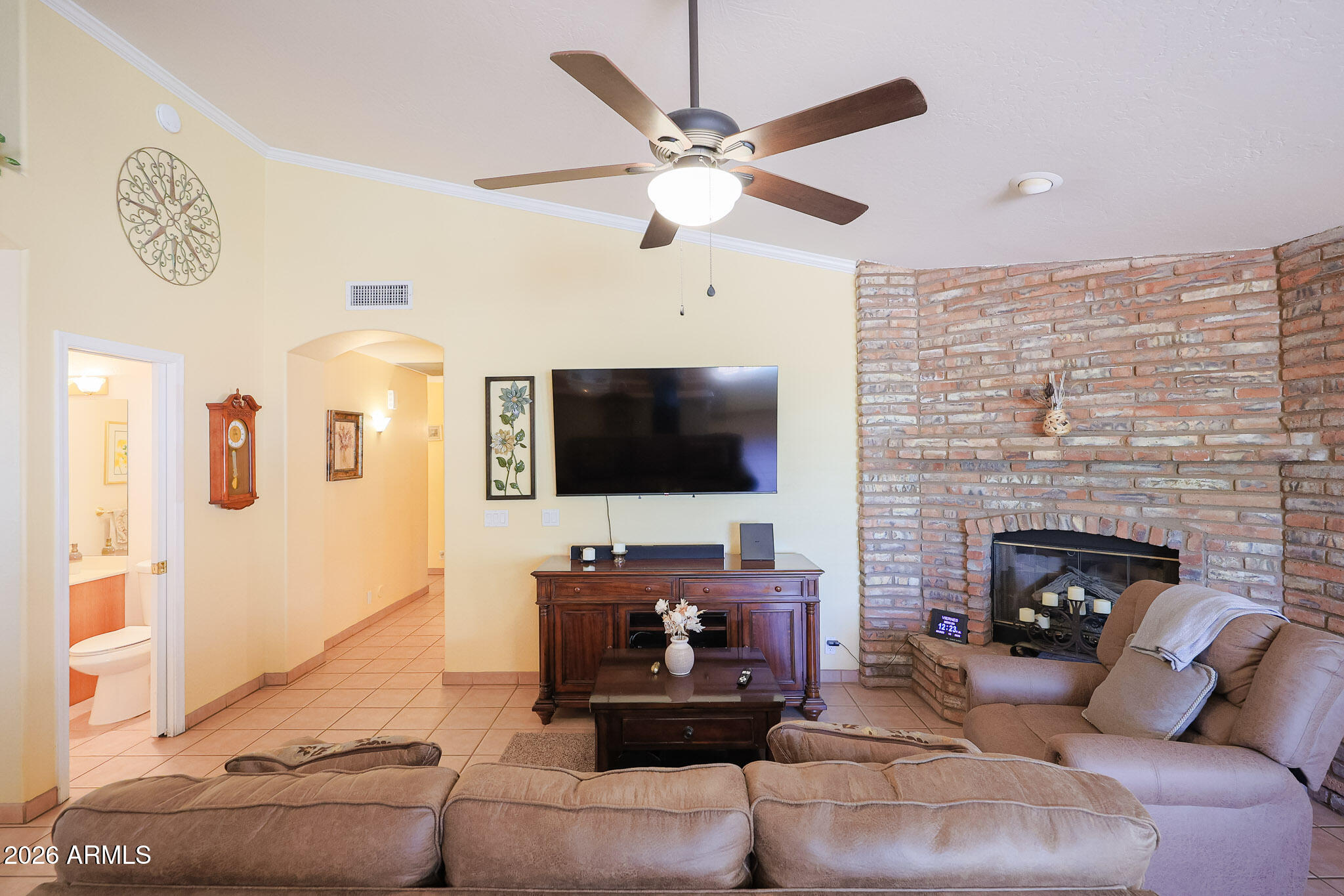 7344 North Alsup Road Litchfield Park, AZ 85340 - Photo 22 of 62 a living room with furniture a flat screen tv and a fireplace