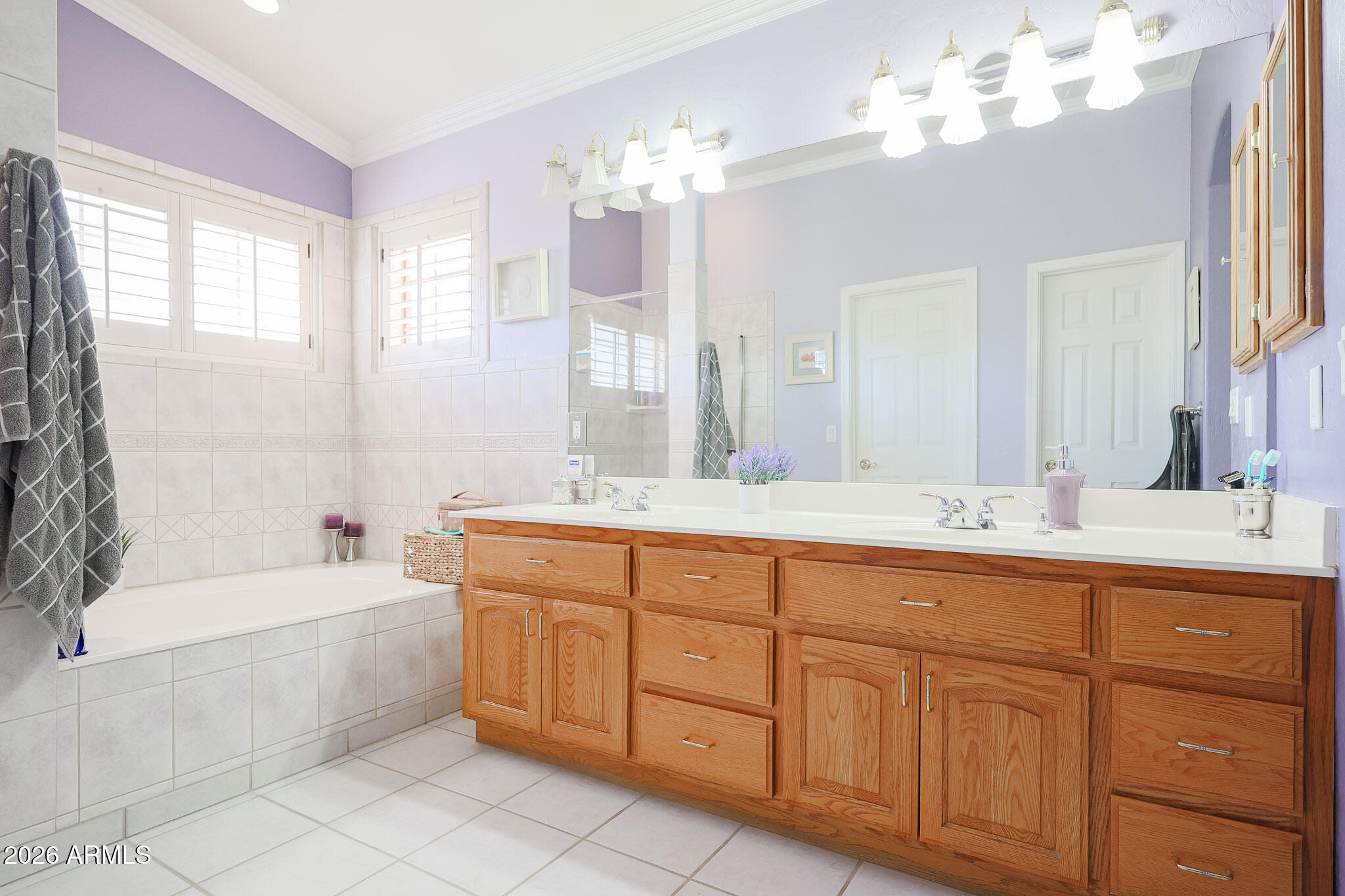 7344 North Alsup Road Litchfield Park, AZ 85340 - Photo 33 of 62 a bathroom with a granite countertop double vanity sink a mirror a bathtub and next to a window