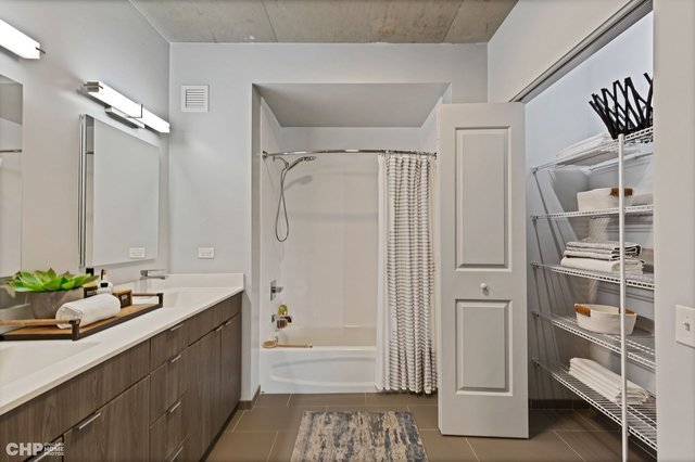 1025 West Addison Street, Unit 805 Chicago, IL 60613 - Photo 14 of 15 a bathroom with a tub sink and mirror