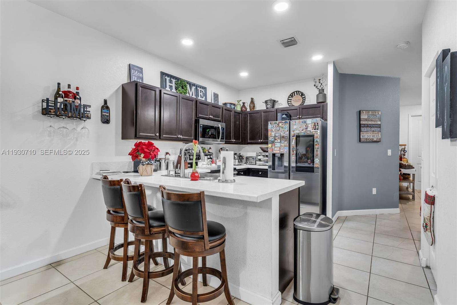11424 Southwest 251st Street Homestead, FL 33032 - Photo 12 of 43 a kitchen with stainless steel appliances kitchen island granite countertop a dining table and chairs