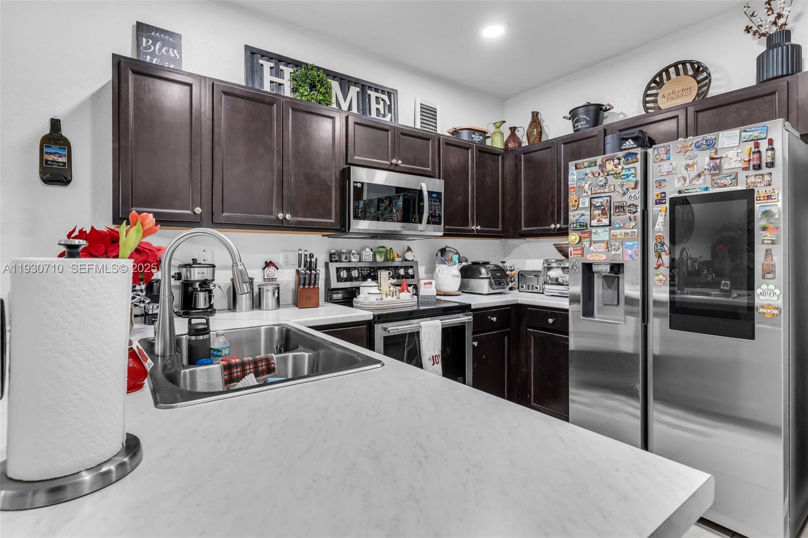11424 Southwest 251st Street Homestead, FL 33032 - Photo 14 of 43 a kitchen with stainless steel appliances granite countertop a sink refrigerator and microwave