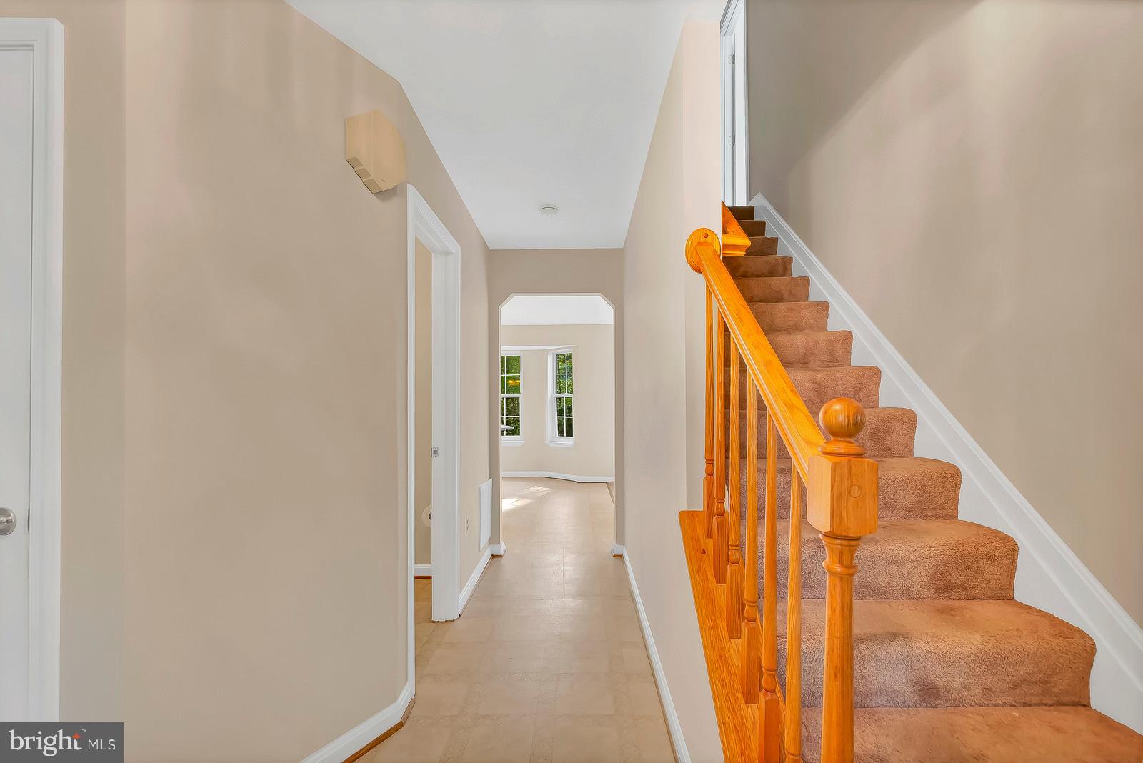 6815 Mackall Road St. Leonard, MD 20685 - Photo 14 of 38 a view of a hallway with wooden floor and staircase