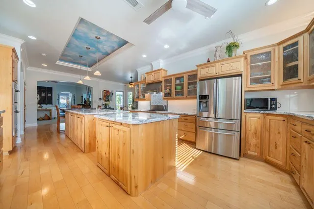 a view of swimming pool with lawn chairs and plants