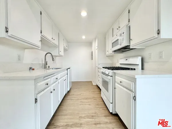 a kitchen with cabinets a sink and appliances