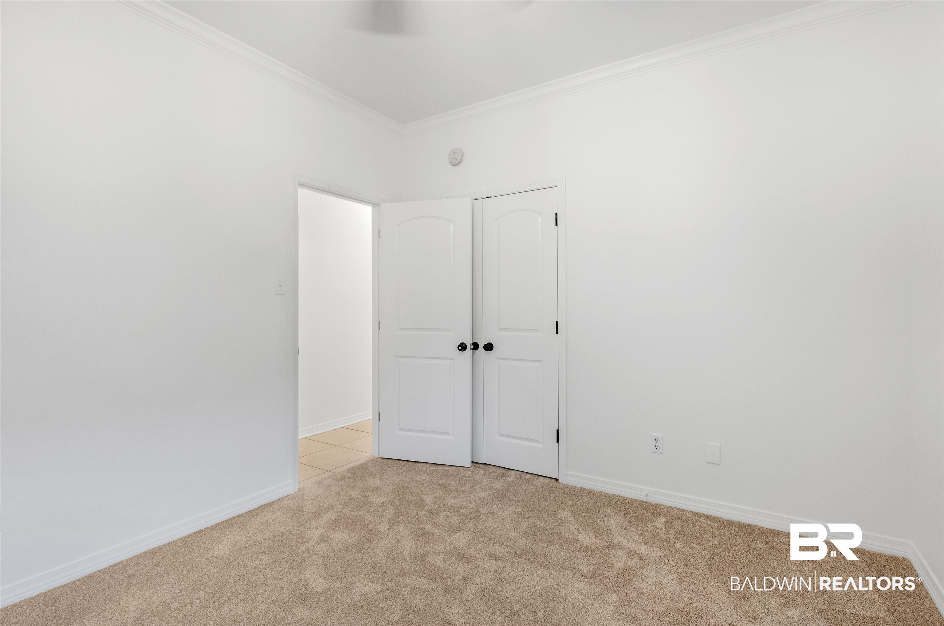 1007 Linlen Avenue Mobile, AL 36609 - Photo 12 of 21 Unfurnished bedroom with a closet, light colored carpet, and ornamental molding