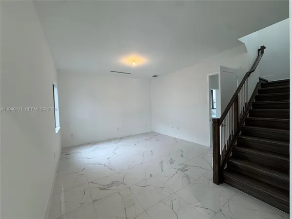 a large kitchen with stainless steel appliances a large counter top a stove and a sink