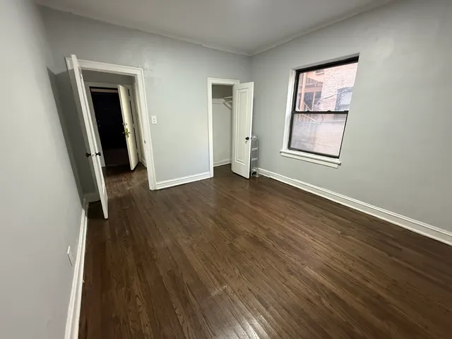 an empty room with wooden floor and a window