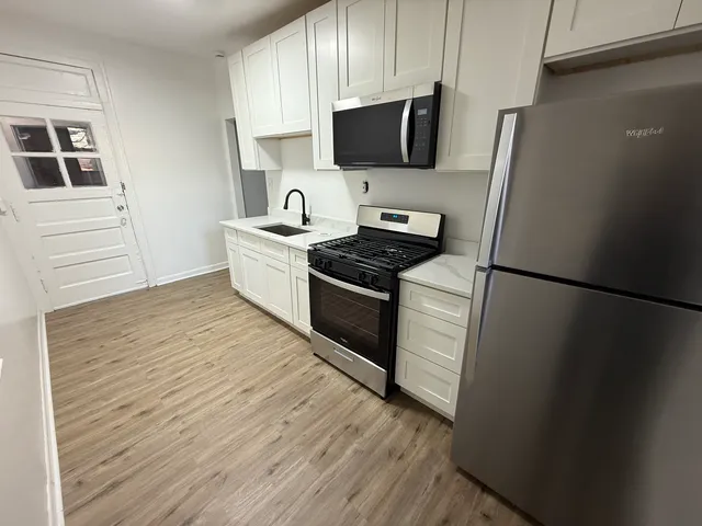 a kitchen with a refrigerator stove and wooden cabinets