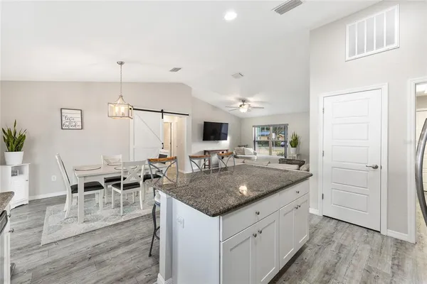 a kitchen with stainless steel appliances granite countertop a sink a stove and a wooden floors