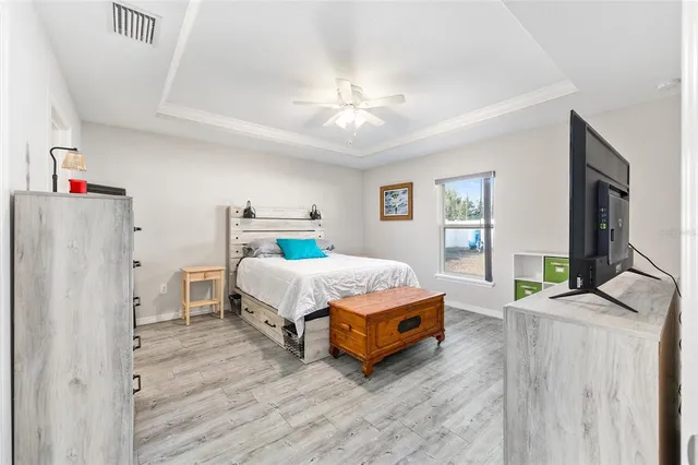 a spacious bedroom with a bed and a chandelier