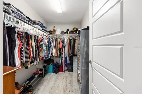 a view of walk in closet with clothes
