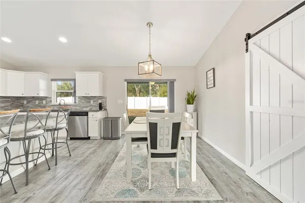 a kitchen with white cabinets and wooden floor